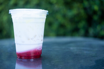 Fresh milk with strawberry layer in plastic cup