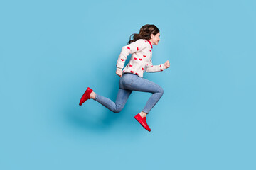 Fototapeta na wymiar Full length photo of hurrying young lady wear hearts print sweater jumping running isolated blue color background