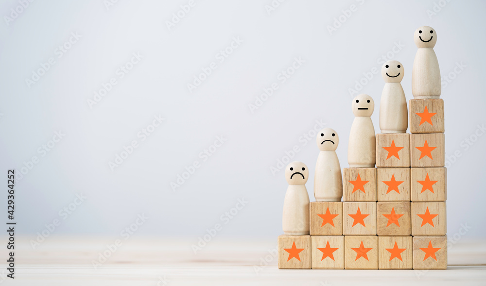 Aufkleber emotion face on wooden miniature figure with stars on wooden cube for the best customer evaluation a