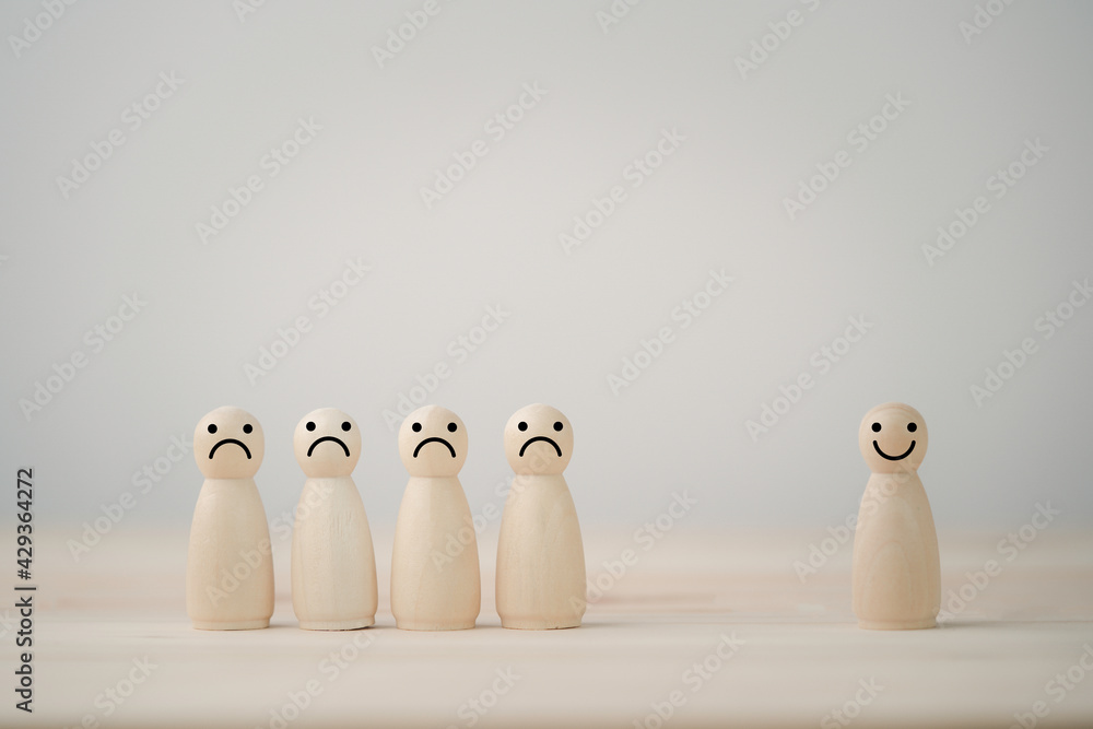 Poster smiley face on wooden mixture figure separate from sadness face on wooden table , emotion select and