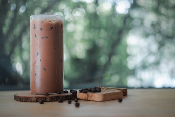 Cold refreshing iced coffee in a tall glass with coffee beans.