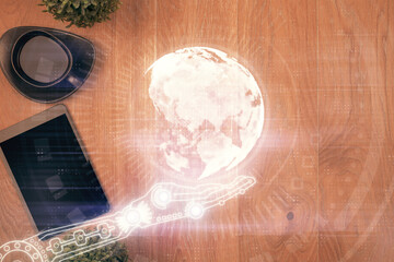 Double exposure of map hologram drawing over desktop. Top view. International connection concept.