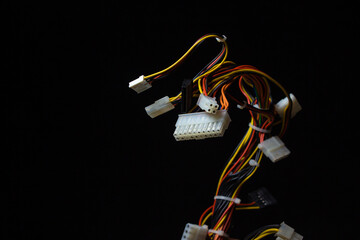 Bundle of computer wires on a black background. Connecting wires on a dark background. Technology and innovation concept