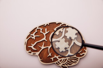 Model of brain and wooden puzzles with magnifier, healthcare concept