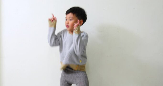 cute little asian boy dance on the floor at home.