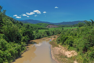 Fototapeta na wymiar river among the hills covered with tropical forest