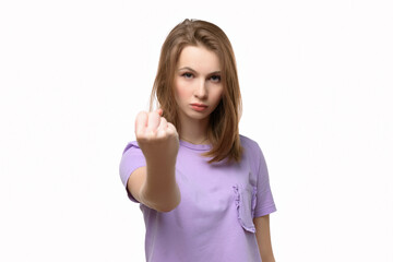 Angry serious girl looking at camera showing fist isolated on white background