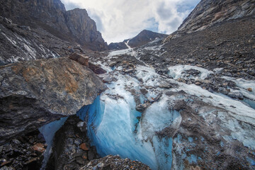 Ice high in the mountains. Small Aktru glacier in the Altai mountains clean ice among the rocks covered with stones