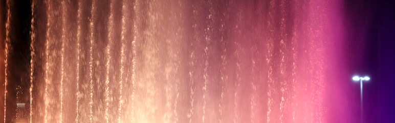 Splashing fountain in pink at night