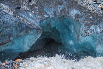 Ice high in the mountains. Small glacier Aktru in the Altai mountains clear ice among the rocks streams of melted water pierce tunnels in the ice