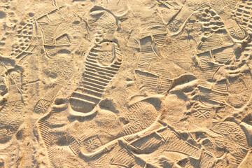 Many footprints from shoes, sandals on the yellow sea sand.