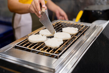 A close-up picture of khao chee (Fire-grilled rice topped with eggs) in Thai street food