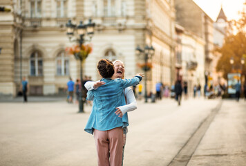 Fototapeta premium Two women on the street. Women in hug.