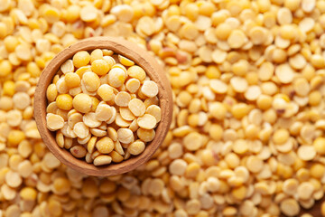Macro Close-up of Organic arhar dal (Cajanus cajan) or split yellow dal in an earthen clay pot (kulhar) on the self background. Top view