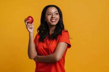 Young black happy woman smiling while posing with apple