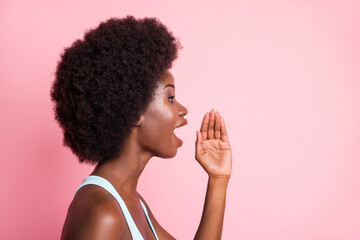 Profile portrait of optimistic brunette curly lady hand talk to empty space wear blue top isolated...