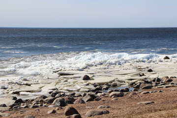 View of the bay and the ice floes near the shore on a sunny spring day 