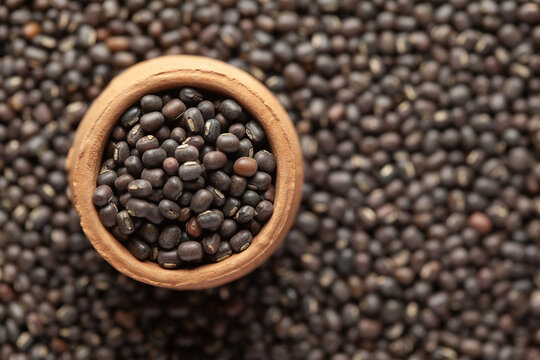 Macro Close Up Of Organic Black Gram (Vigna Mungo) Or Whole Black Urad In An Earthen Clay Pot (kulhar) On The Self Background. Top View