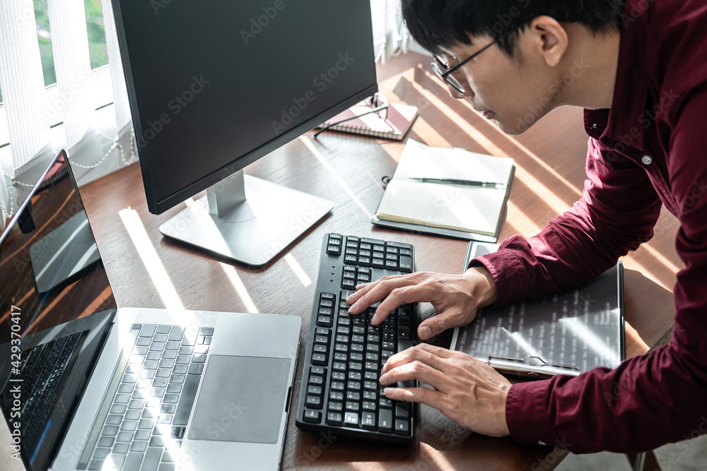 Poster Asian man programmer looking on screen laptop to typing code data with keyboard about website and applications