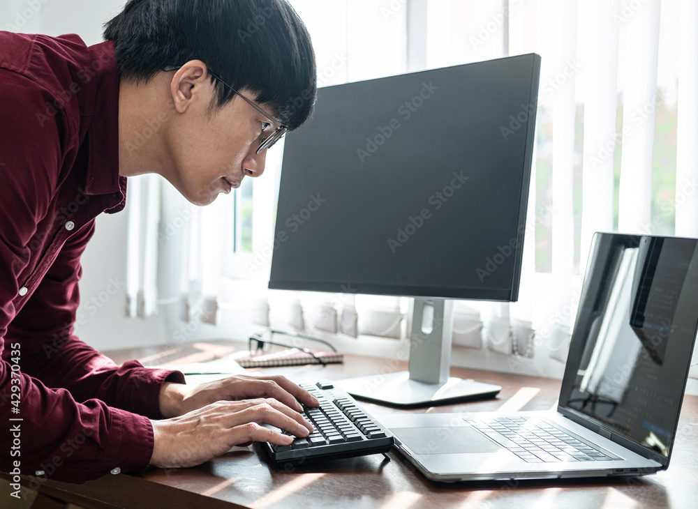 Poster Asian man programmer looking on screen laptop to typing code data with keyboard about website and applications