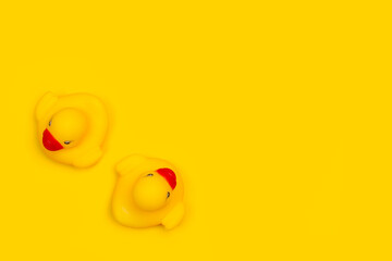 Fototapeta premium Dos patos de goma sobre un fondo amarillo liso y aislado. Vista superior. Copy space