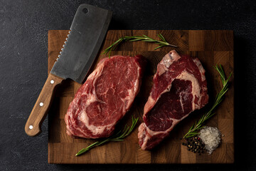 Raw marbled beef steak on a wooden cutting board. Top class marbled beef. Graphite-colored table top.