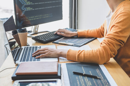 Young Professional programmer working at developing programming and website working in a software develop company office, writing codes and typing data code, Programming with HTML, PHP and javascript