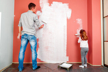 father and daughter paint the wall in the room. home renovation