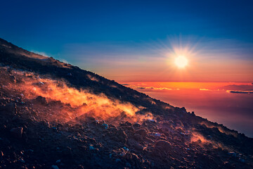 Marvelous sunset over the horizon, haze coming from the warm ground of an active volcano