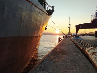 a cargo ship and cranes and machinery in the port of Bilbao, Spain, one morning at dawn