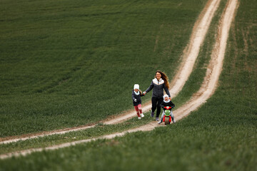Mother plays with her children cheerfully in the field. family concept.