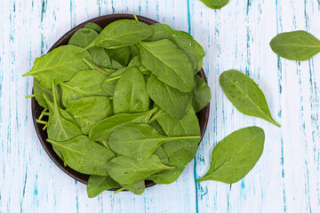 Top View of Fresh Green Spinach Leaves in Wooden Bowl