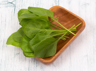 Baby spinach leaves in wooden bowl