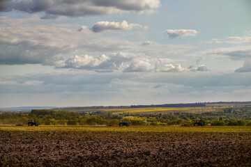 Spring agricultural agricultural works. Tractors plow the land and view of the spring fields.