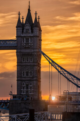 Closeup view to a colorful sunset behind the iconic Tower Bridge in London, United Kingdom, with street traffic