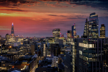 Elevated panorama of the illuminated skyline of the City of London during dusk, United Kingdom