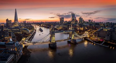 Zelfklevend Fotobehang Panoramic, aerial view to the cityscape of London with Tower Bridge and the illuminated skyscrapers of the city during dusk, United Kingdom © moofushi