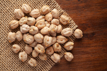 Macro Close-up of Organic Chole Chana or Kabuli Chana (Cicer arietinum) or whole white Bengal Gram Dal on Jute mat and wooden top