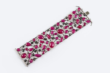 Fashion bracelet with diamonds and sapphire natural gem stones on gray background. Pink and black precious stones in luxury diamond jewelry bracelet