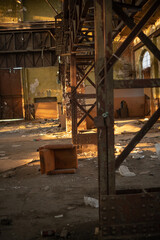 Old abandoned brick and concrete warehouse with a lot of rubbish around during the late afternoon spring sunset.