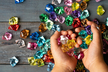 カラフルなアクリルストーンで遊ぶ子供の手