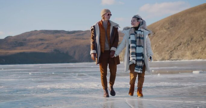 The girl with the bionic prosthesis and her boyfriend are walking along a frozen Baikal lake Bionics Cybernetic Robotic-arm Hand prosthesis Baikal