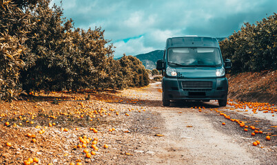 Journey. Vanlife. Campervan on the road in the mandarin orchard.