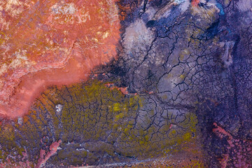 Aerial drone view of industrial chemicals dump site, dry multicolored soil, unique texture.