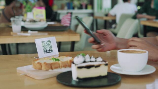 woman scanning the QR code to order food and pay money. Restaurants protect virus by place barcode labels for customers to scan for paying for food. Concept online.