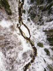 Aerial view of winding river, bridge, island and forest in Riezupe river nature park in winter day,...