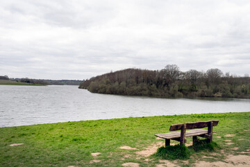 Naklejka na ściany i meble Wooden bench, empty, on the shore of Bewl water reservoir, South East England