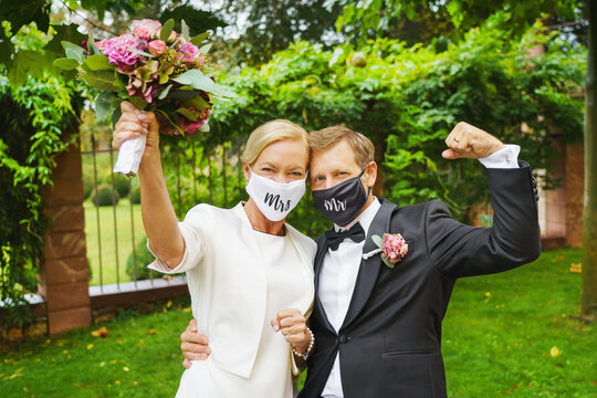 happy bride and groom in respirator on wedding