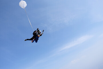 Fototapeta na wymiar Skydiving. Tandem jump. Man and woman in the sky.