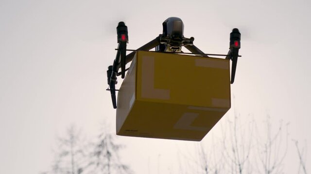 big delivery drone carrying parcel in the sunlight